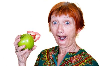 Old woman biting an apple